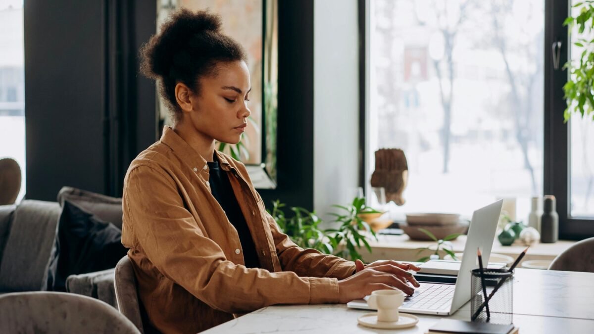 A woman working on a laptop creating virtual marketing strategies and brand design