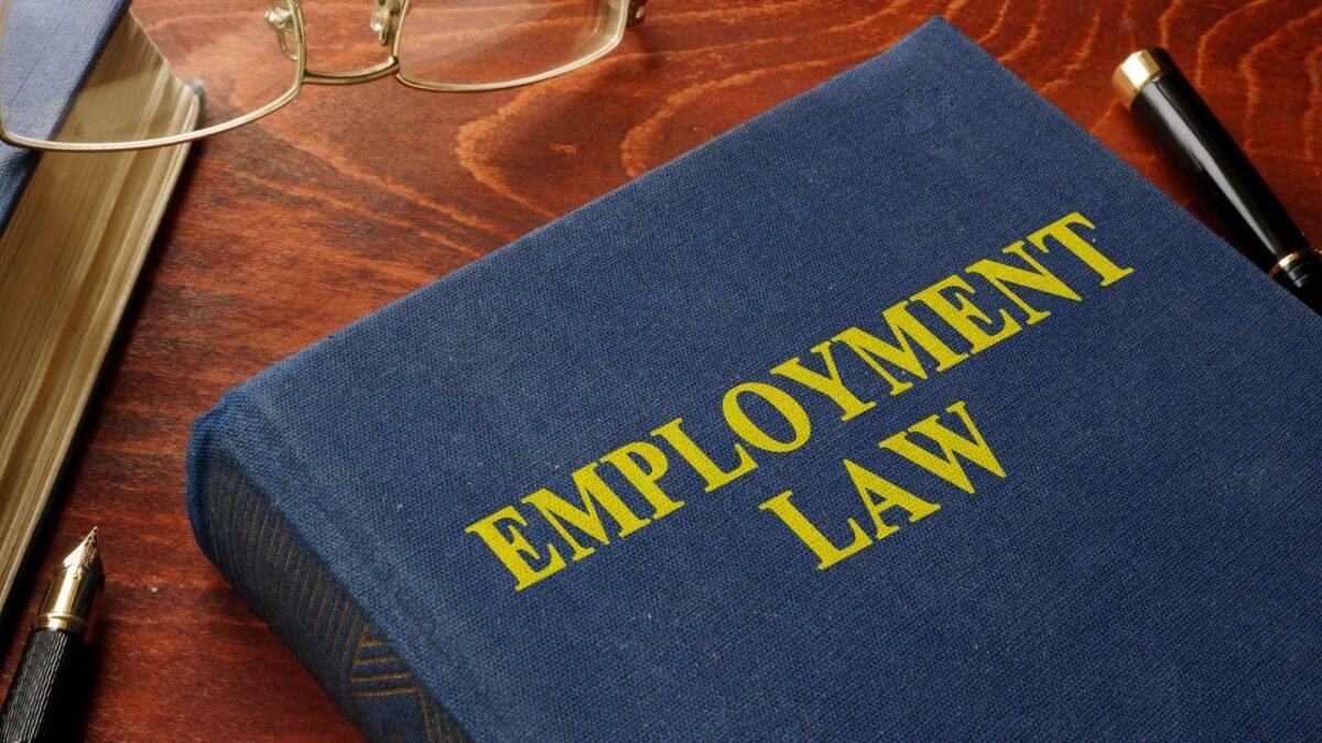 An employment law book placed along with a pen and glasses